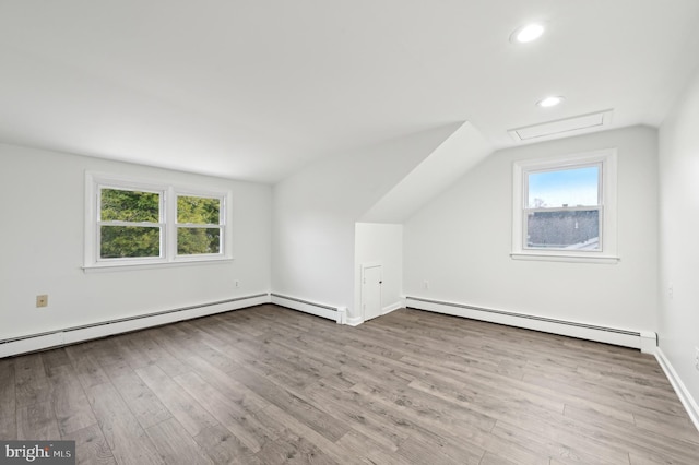 bonus room featuring a baseboard heating unit, recessed lighting, wood finished floors, and lofted ceiling