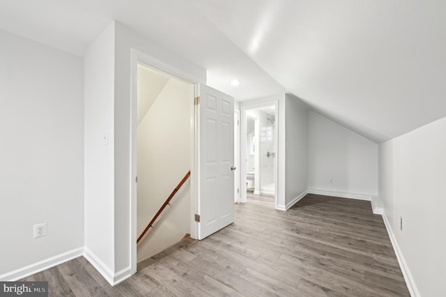 bonus room with vaulted ceiling, wood finished floors, and baseboards