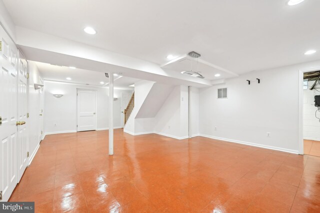 finished below grade area with recessed lighting, visible vents, baseboards, and stairs