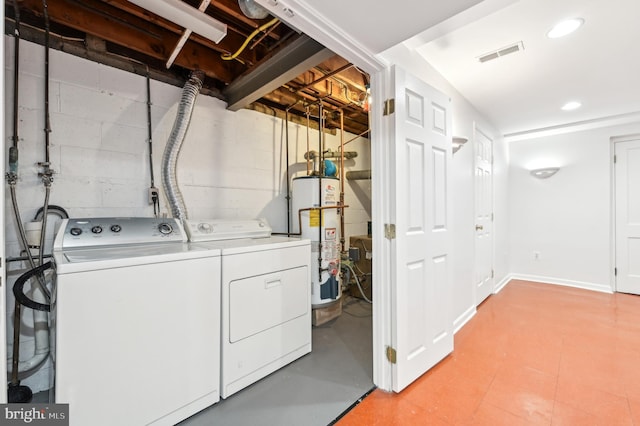 clothes washing area with laundry area, visible vents, washer and dryer, gas water heater, and recessed lighting