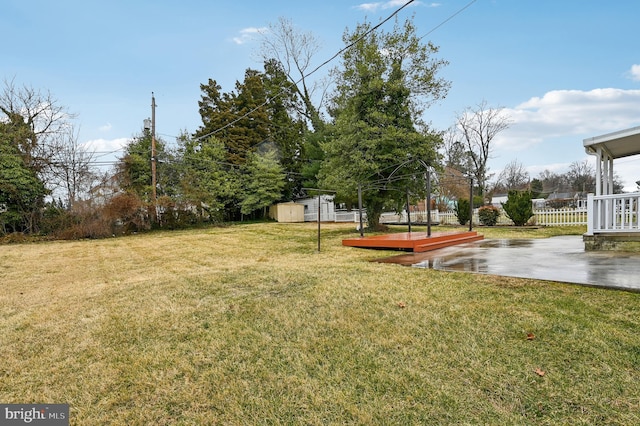 view of yard featuring a shed, fence, and an outdoor structure