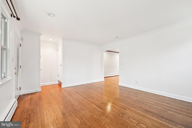 spare room with light wood-type flooring, a baseboard radiator, baseboard heating, and crown molding