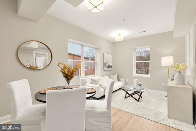 dining room with visible vents, baseboards, and wood finished floors