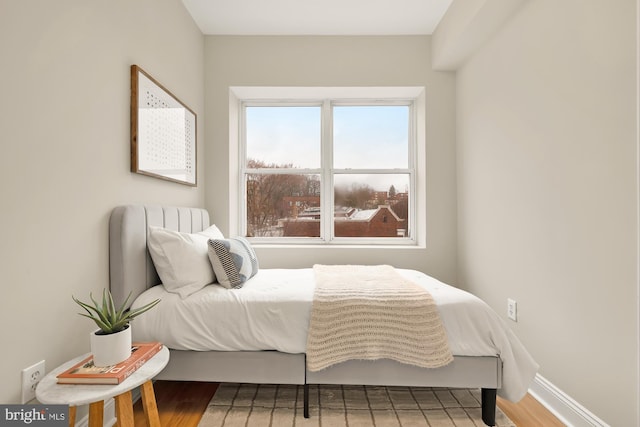 bedroom featuring baseboards and wood finished floors