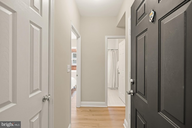 hall featuring light wood finished floors and baseboards