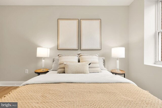 bedroom featuring wood finished floors and baseboards