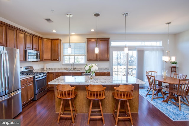 kitchen featuring appliances with stainless steel finishes, brown cabinetry, and a sink