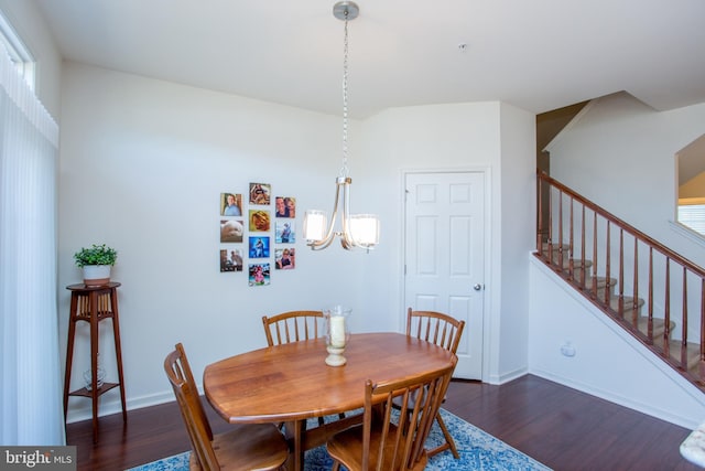 dining room featuring baseboards, stairway, a chandelier, and wood finished floors