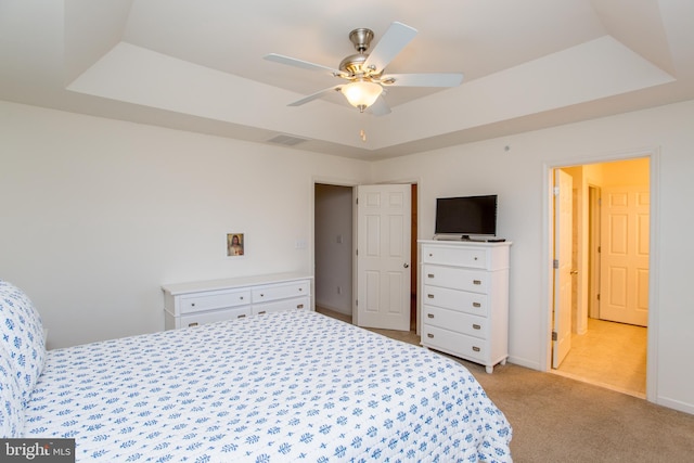 bedroom with visible vents, baseboards, a ceiling fan, light colored carpet, and a tray ceiling