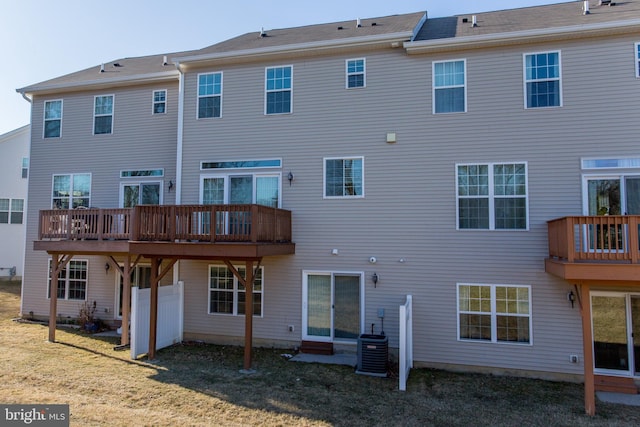 back of property featuring a lawn and central air condition unit