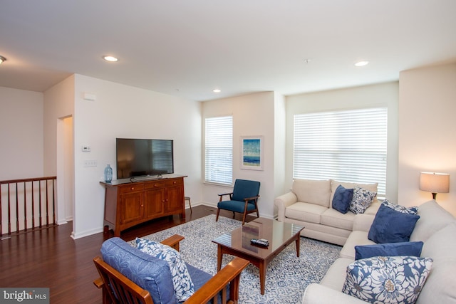 living area with dark wood-type flooring, a wealth of natural light, baseboards, and recessed lighting