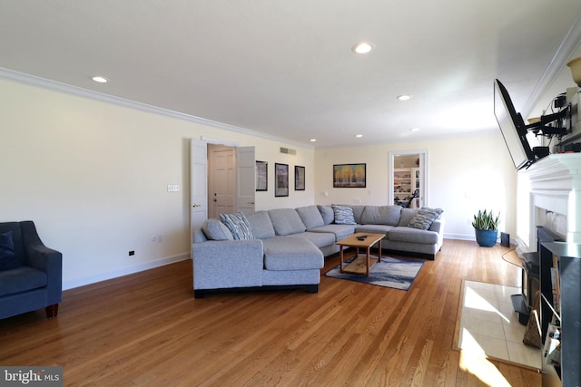 living room with baseboards, light wood-style flooring, and crown molding