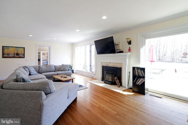 living area with crown molding, visible vents, wood finished floors, and recessed lighting