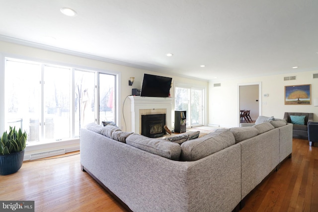 living room featuring ornamental molding, recessed lighting, visible vents, and wood finished floors