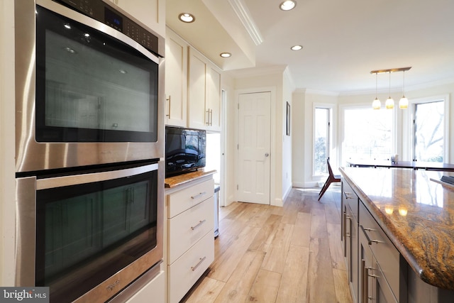 kitchen with white cabinetry, double oven, black microwave, and ornamental molding