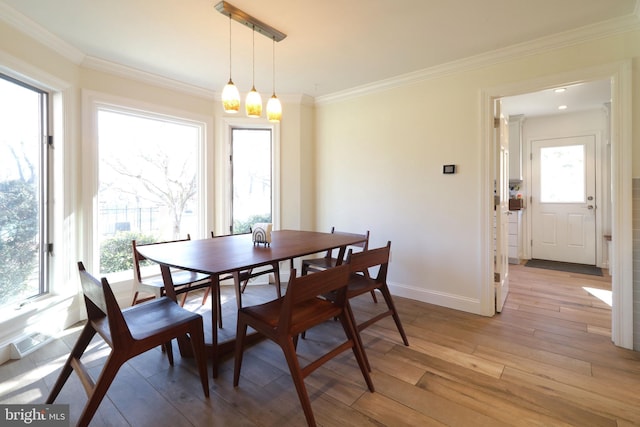 dining space with light wood-type flooring, visible vents, baseboards, and crown molding