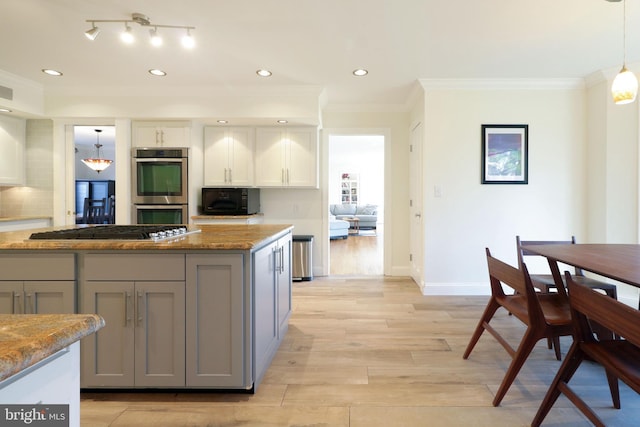 kitchen featuring baseboards, light wood-style flooring, stainless steel appliances, crown molding, and gray cabinetry