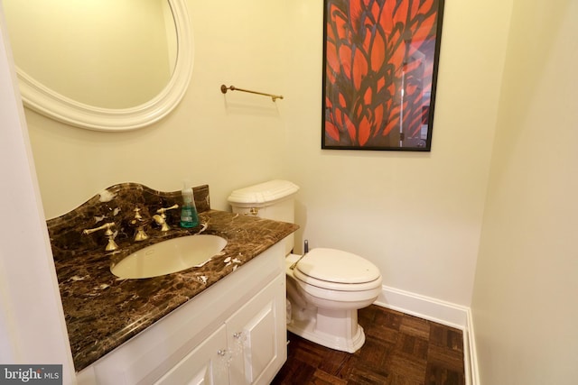 bathroom featuring vanity, toilet, and baseboards