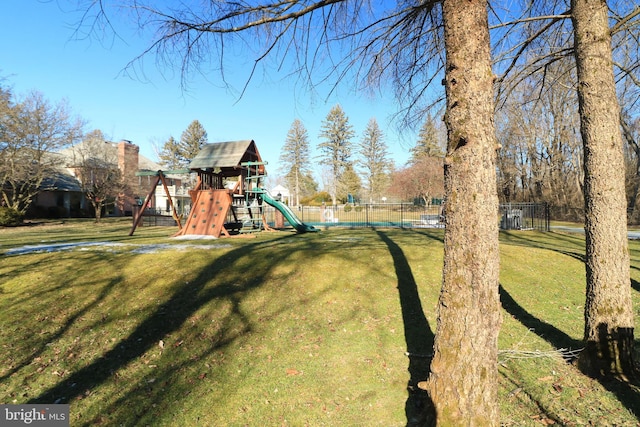 community playground featuring fence and a lawn