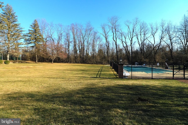 view of yard with a fenced in pool and fence