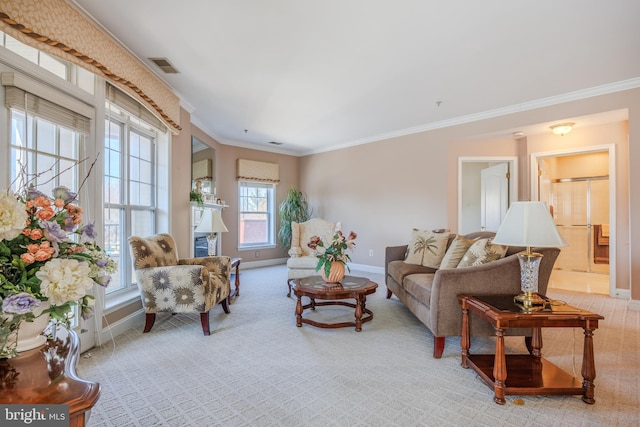 living room featuring light carpet, visible vents, baseboards, a glass covered fireplace, and crown molding