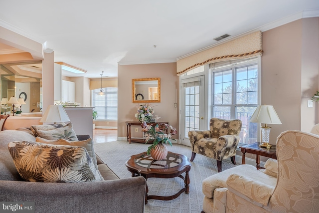 living area featuring visible vents, crown molding, and baseboards