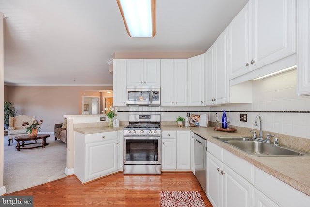 kitchen featuring white cabinetry, tasteful backsplash, appliances with stainless steel finishes, and a sink