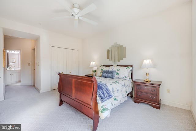 bedroom with baseboards, a ceiling fan, connected bathroom, light colored carpet, and a closet