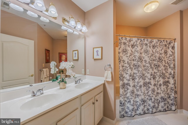 bathroom with visible vents, a sink, and double vanity