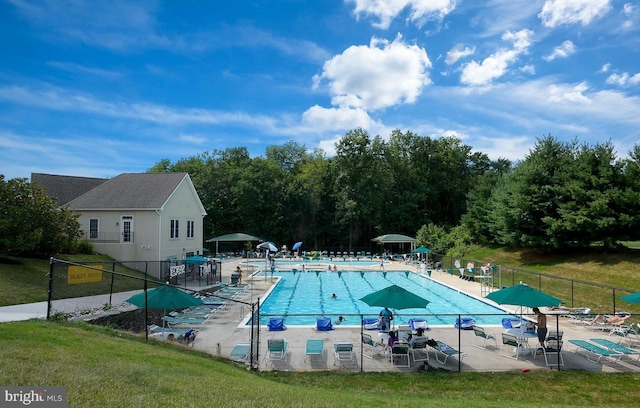 pool with a patio area, fence, and a lawn