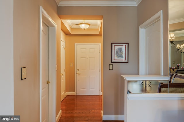 hall featuring ornamental molding, wood finished floors, and baseboards