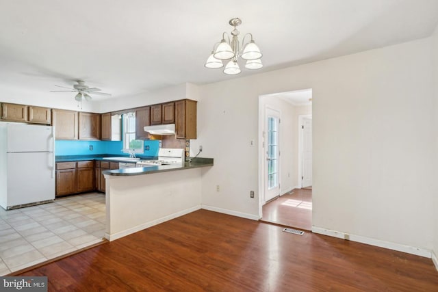 6621 Schoolhouse Rd, Bealeton, VA 22712 - kitchen featuring freestanding refrigerator, range, under cabinet range hood, a peninsula, and a chandelier