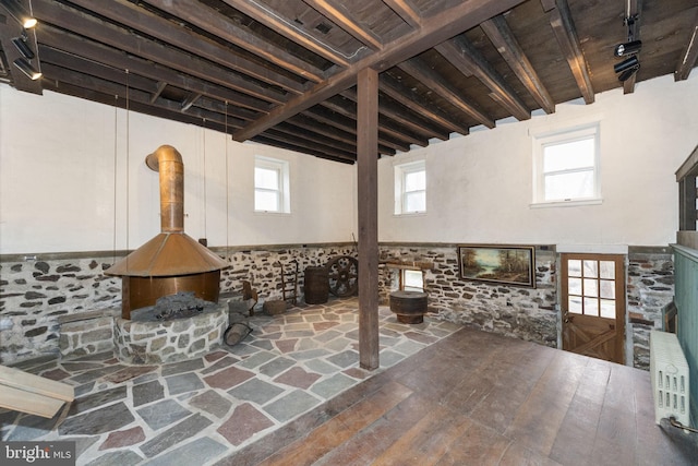 interior space featuring plenty of natural light, track lighting, and a wood stove