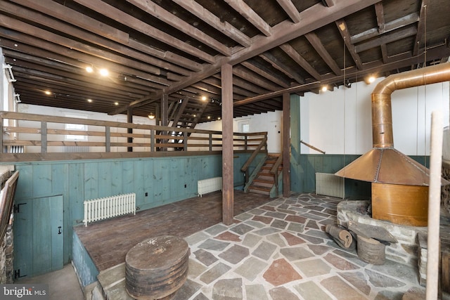 finished basement featuring stairway and radiator