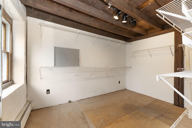 spacious closet featuring baseboard heating and beamed ceiling