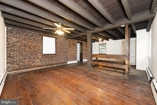 below grade area with dark wood-style floors, baseboard heating, brick wall, and ceiling fan