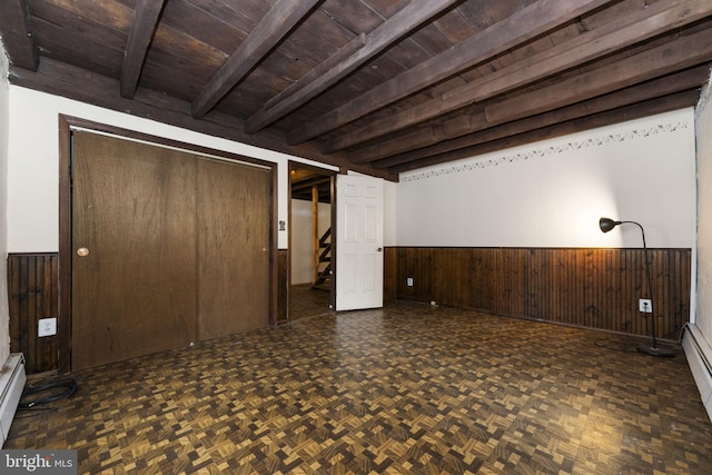 below grade area with wooden ceiling, a wainscoted wall, and wood walls