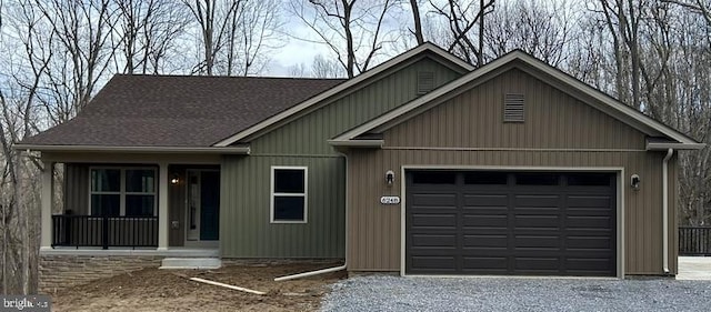 view of front facade featuring a garage, gravel driveway, and roof with shingles