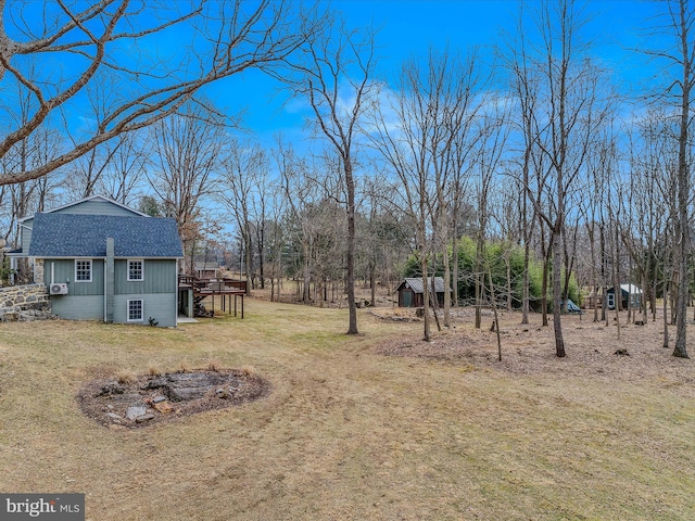 view of yard featuring a deck, a shed, and an outdoor structure