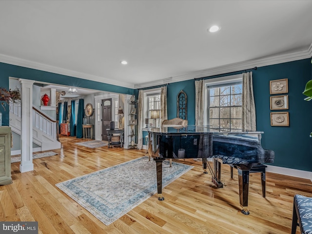 sitting room featuring ornate columns, baseboards, crown molding, and wood finished floors