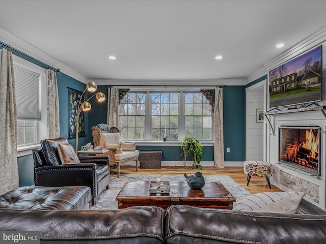 living room with recessed lighting, ornamental molding, wood finished floors, a warm lit fireplace, and baseboards