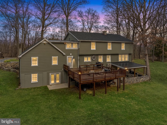 back of house with a deck, french doors, a lawn, and a chimney