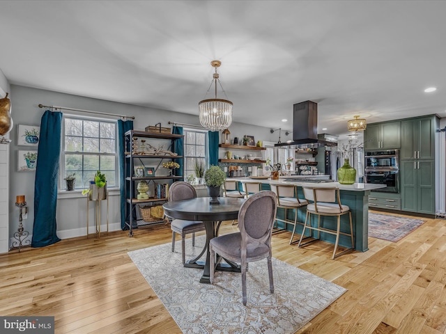 dining area featuring light wood-style flooring, baseboards, a notable chandelier, and recessed lighting