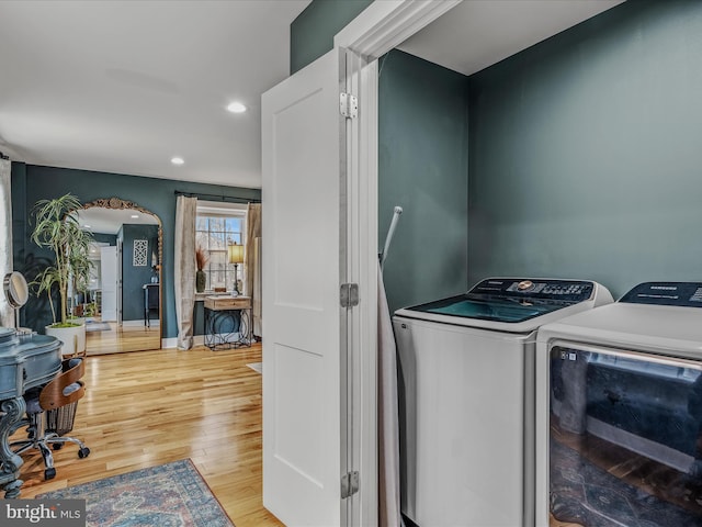 washroom featuring arched walkways, recessed lighting, laundry area, wood finished floors, and washing machine and clothes dryer