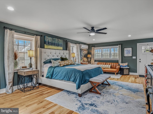 bedroom with recessed lighting, an AC wall unit, ceiling fan, wood finished floors, and baseboards