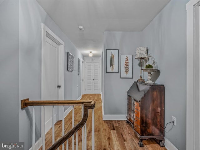 corridor with wood finished floors and baseboards