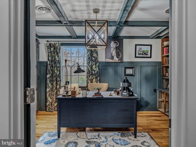 interior space featuring coffered ceiling, wainscoting, visible vents, and wood finished floors