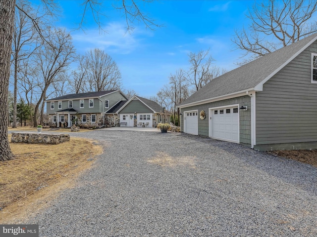 view of front of home featuring a garage, an outdoor structure, and a shingled roof