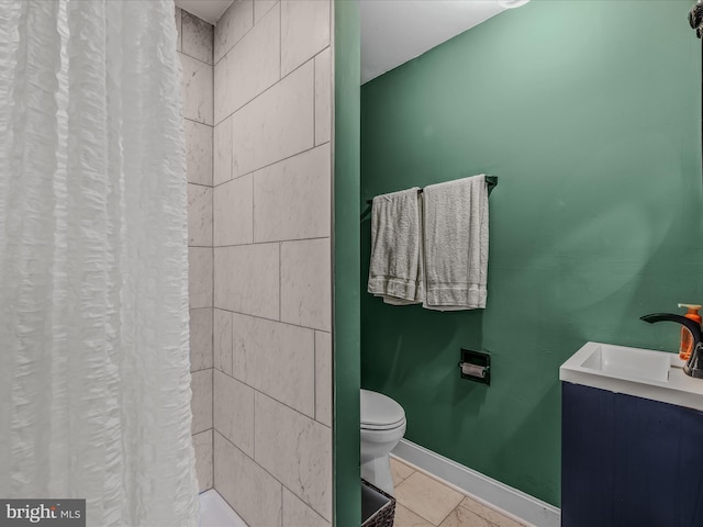 bathroom with curtained shower, toilet, a sink, baseboards, and tile patterned floors