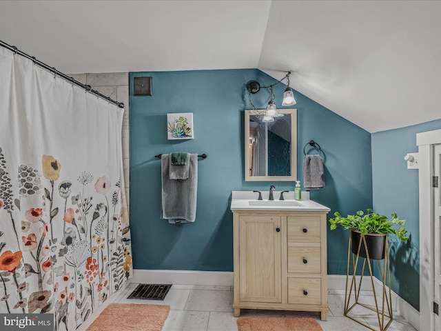 bathroom featuring lofted ceiling, baseboards, visible vents, and vanity